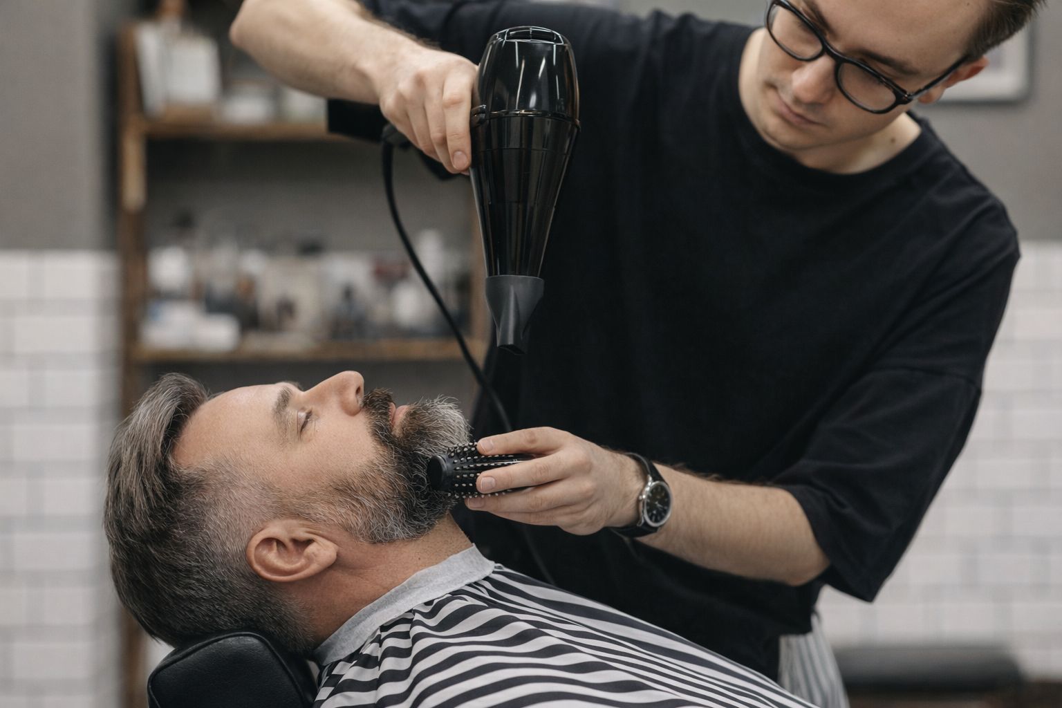 En stylist fönar och borstar en mans skägg och hår på en salong.